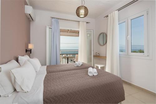 a bedroom with a bed with a view of the ocean at The Wave in Sidari