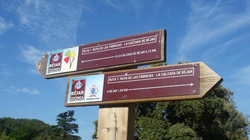 two signs on top of a wooden pole at La Covatilla III in La Hoya