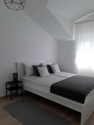 - une chambre blanche avec un lit et une fenêtre dans l'établissement Apartment Pepina, à Vodice