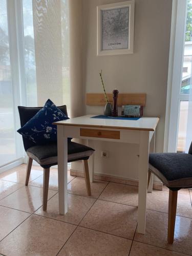 a white table and two chairs in a room at Hotel-Bistro-Europa in Merchweiler