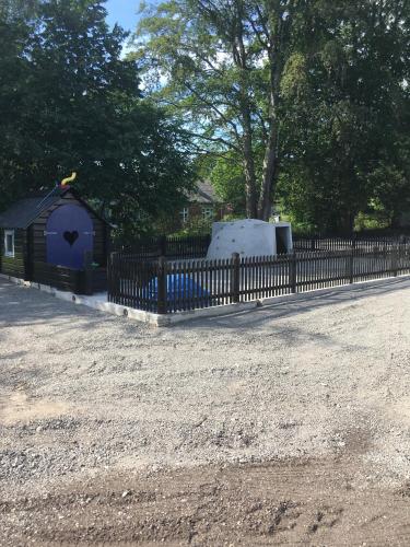a black fence next to a yard with a house at Hedegaard Holiday Apartments in Give