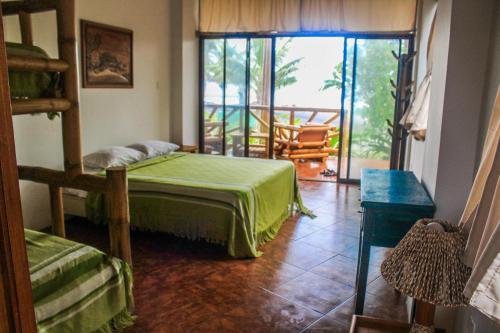 a bedroom with a bed and a balcony at Seaside Garden Ecolodge Mompiche in Mompiche