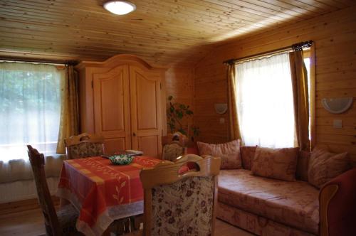 a dining room with a table and a couch in a room at Horváth Kert Vendégház in Zirc