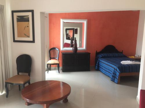 a bedroom with a bed and a table and chair at Casa del Parque Vallarta in Puerto Vallarta