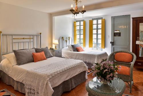 a bedroom with two beds and a table at Finca Hotel Los Girasoles in Montenegro