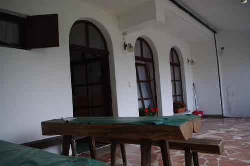 a wooden table in front of a building with windows at Horváth Kert Vendégház in Zirc