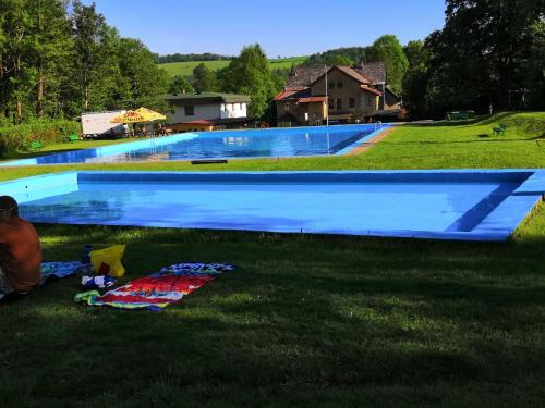a large swimming pool in the middle of a yard at Roubenka Zlatá Olešnice in Zlatá Olešnice