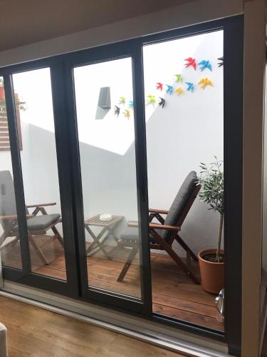 a room with sliding glass doors with a rocking chair at Porta 20 in Loulé