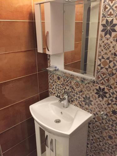 a bathroom with a sink and a mirror at Family Hotel Malibu in Chernomorets