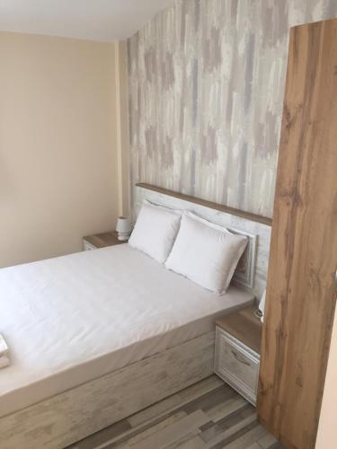 a bedroom with a bed with white sheets and pillows at Family Hotel Malibu in Chernomorets