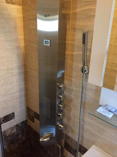 a shower with a glass door in a bathroom at Family Hotel Malibu in Chernomorets