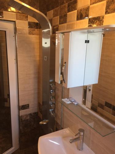 a bathroom with a sink and a mirror at Family Hotel Malibu in Chernomorets