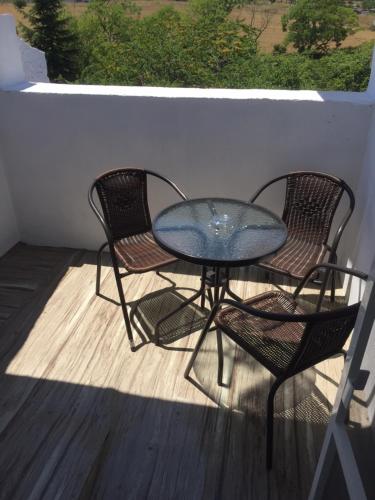 two chairs and a glass table on a balcony at Family Hotel Malibu in Chernomorets