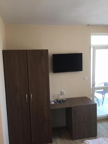 a room with a desk and a tv on a wall at Family Hotel Malibu in Chernomorets