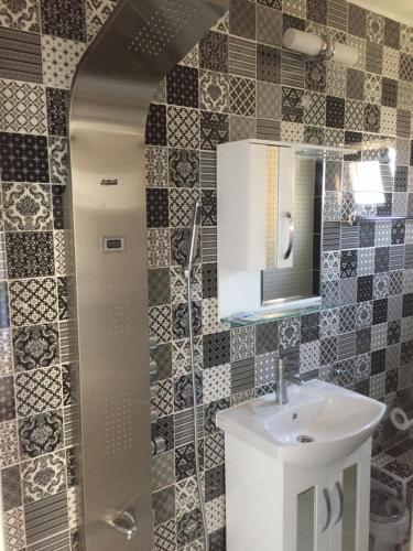 a bathroom with a sink and a mirror at Family Hotel Malibu in Chernomorets