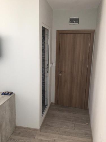 a hallway with a wooden door in a room at Family Hotel Malibu in Chernomorets