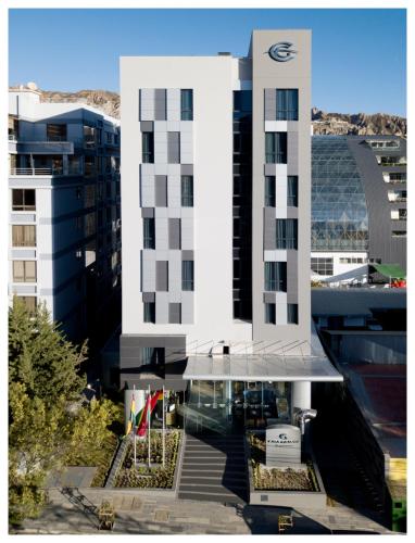 a tall white building with a reflection in the water at Casa Grande Express in La Paz