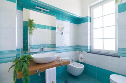 a bathroom with a sink and a mirror at AQUAMARINE Relaxing Capri Suites in Capri