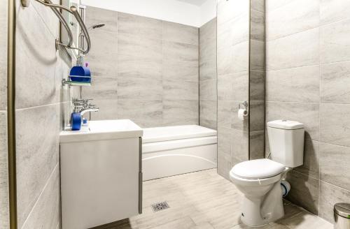 a bathroom with a toilet and a sink and a tub at Apartamente Azzurro on the beach in Mamaia Sat/Năvodari