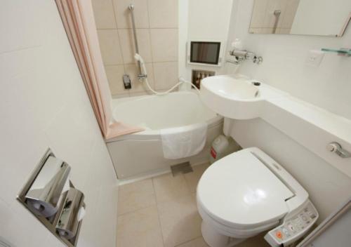 a bathroom with a toilet and a sink and a tub at Dormy Inn Express Matsue in Matsue