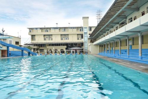 une piscine en face d'un bâtiment dans l'établissement Hotel Olimpico en Quevedo, à Quevedo