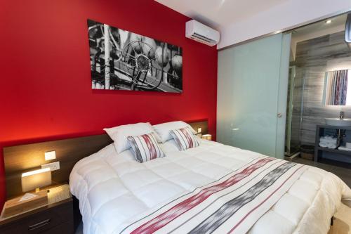 a bedroom with a red wall with a large bed at The Shipwright's Lodge in Marsaxlokk