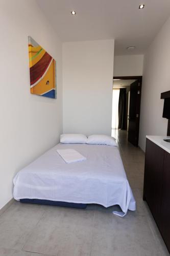 a bedroom with a bed and a painting on the wall at The Shipwright's Lodge in Marsaxlokk