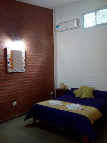 a bedroom with a bed and a mirror and a window at El Chinchero Departamentos in Merlo