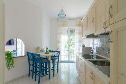 a kitchen with a sink and a table with chairs at AQUAMARINE Relaxing Capri Suites in Capri