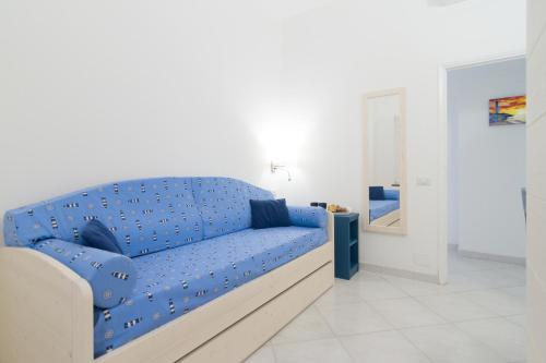 a blue couch with blue pillows in a white room at AQUAMARINE Relaxing Capri Suites in Capri
