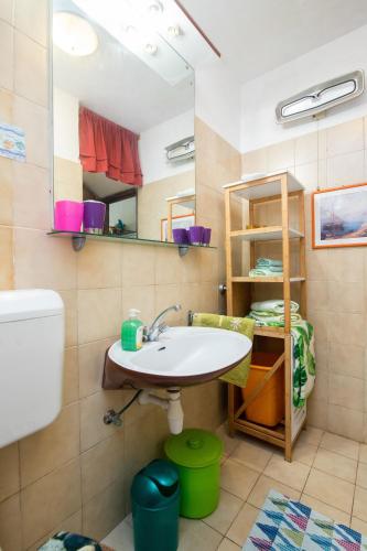 a bathroom with a sink and a toilet and a mirror at Apartment Sanka in Gdinj