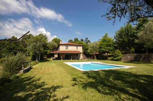 a large yard with a swimming pool in front of a house at Quinta do Castelo in Arcos de Valdevez