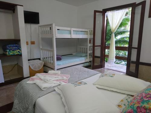 a room with two bunk beds and a couch at Pousada Brasil Paraty in Paraty