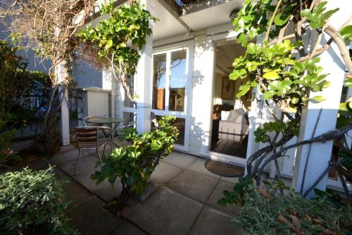 a patio with a table and chairs on a house at Akaroa Village Inn in Akaroa