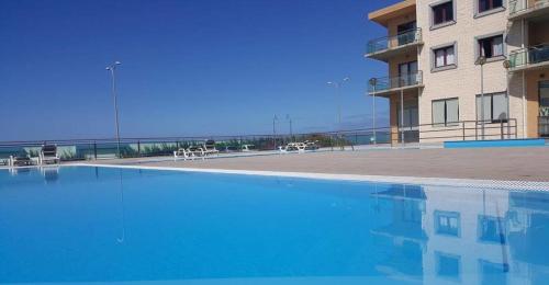 a large swimming pool next to a building at Ericeira Sea&Sun Apartment 2 in Ericeira