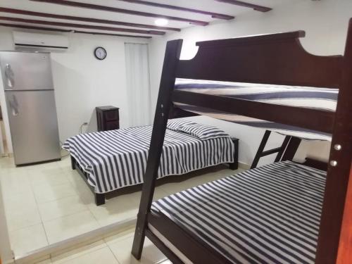 two bunk beds in a room with a refrigerator at El Hostal By Pochet in San Andrés