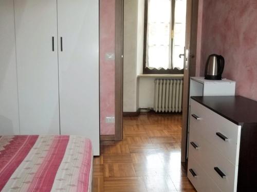 a bedroom with a bed and a dresser and a window at B&B dei Laghi in Brebbia