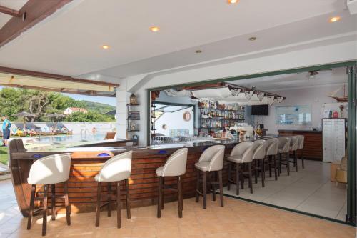 a bar in a restaurant with white chairs at The Wave in Sidari