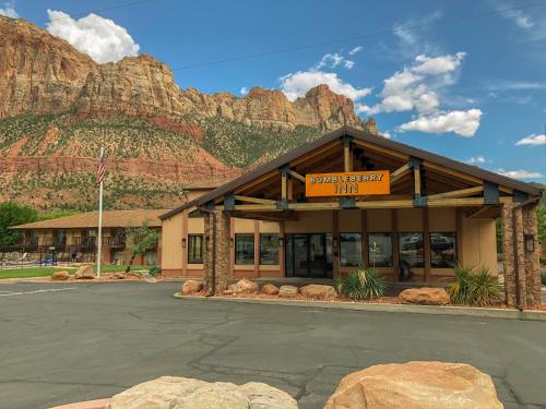 a building with a mountain in the background at Bumbleberry Inn in Springdale