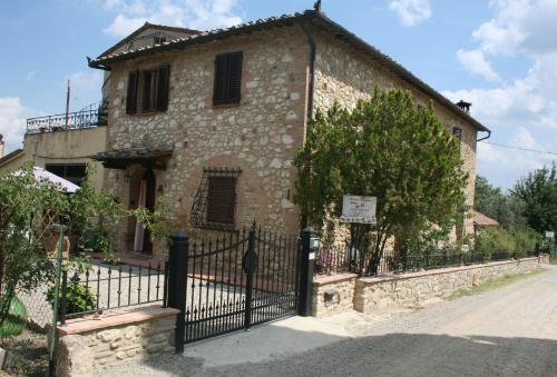 ein altes Steinhaus mit einem schwarzen Zaun in der Unterkunft Antico Casolare in San Gimignano