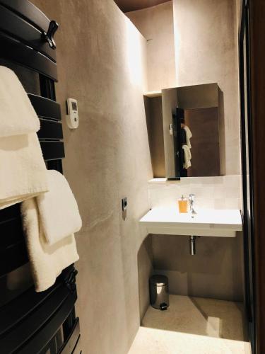 une salle de bain avec un lavabo, un miroir et des serviettes dans l'établissement Maison d'architecte en plein cœur d'Honfleur avec bain nordique, à Honfleur