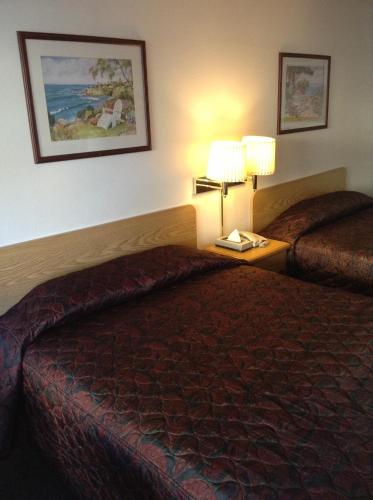 um quarto de hotel com duas camas e duas lâmpadas em Coeur D' Alene Budget Saver Motel em Coeur d'Alene