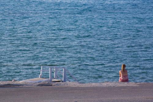 a woman standing on the beach looking at the water at The Wave in Sidari