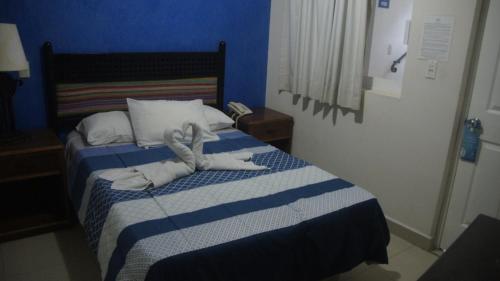 a hotel room with a bed with towels on it at Casa del Parque Vallarta in Puerto Vallarta