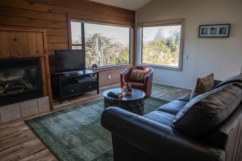 a living room with a couch and a television at Cottages at Little River Cove in Little River