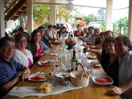 a group of people sitting around a long table at The Sea Garden House in Olón