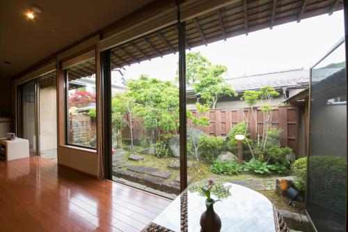 a room with a large glass door with a garden outside at Sekitaitei Ishida in Achi