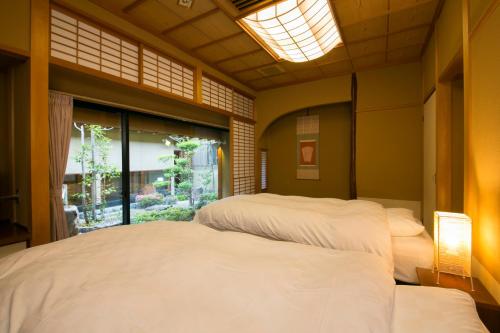 2 camas en una habitación con ventana en Sekitaitei Ishida en Achi