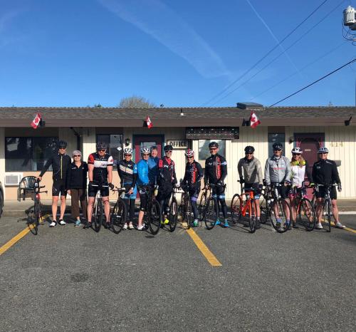 a group of people standing in a parking lot with their bikes at VIP Motel in Parksville