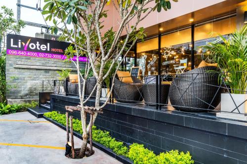 a store front with a tree in front of it at Livotel Hotel Hua Mak Bangkok in Bangkok